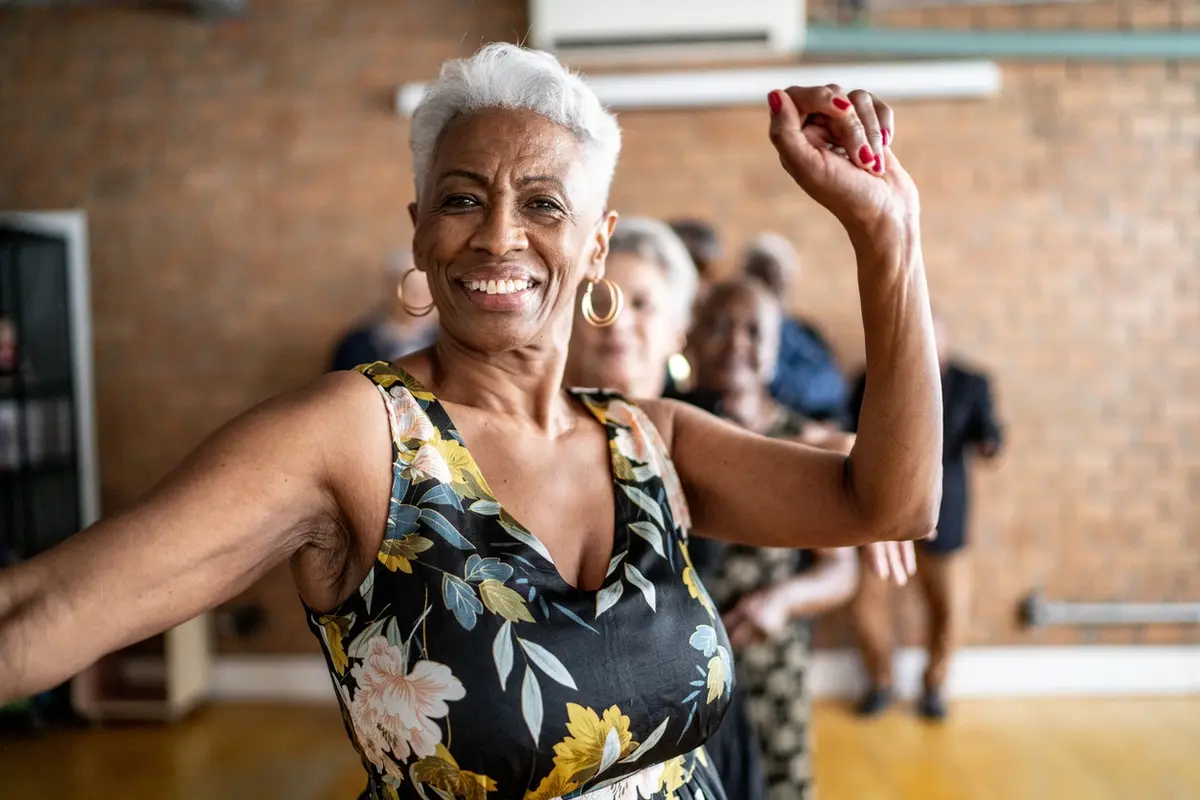 Senior woman staying active through physical therapy exercises for seniors at a community dance and movement class