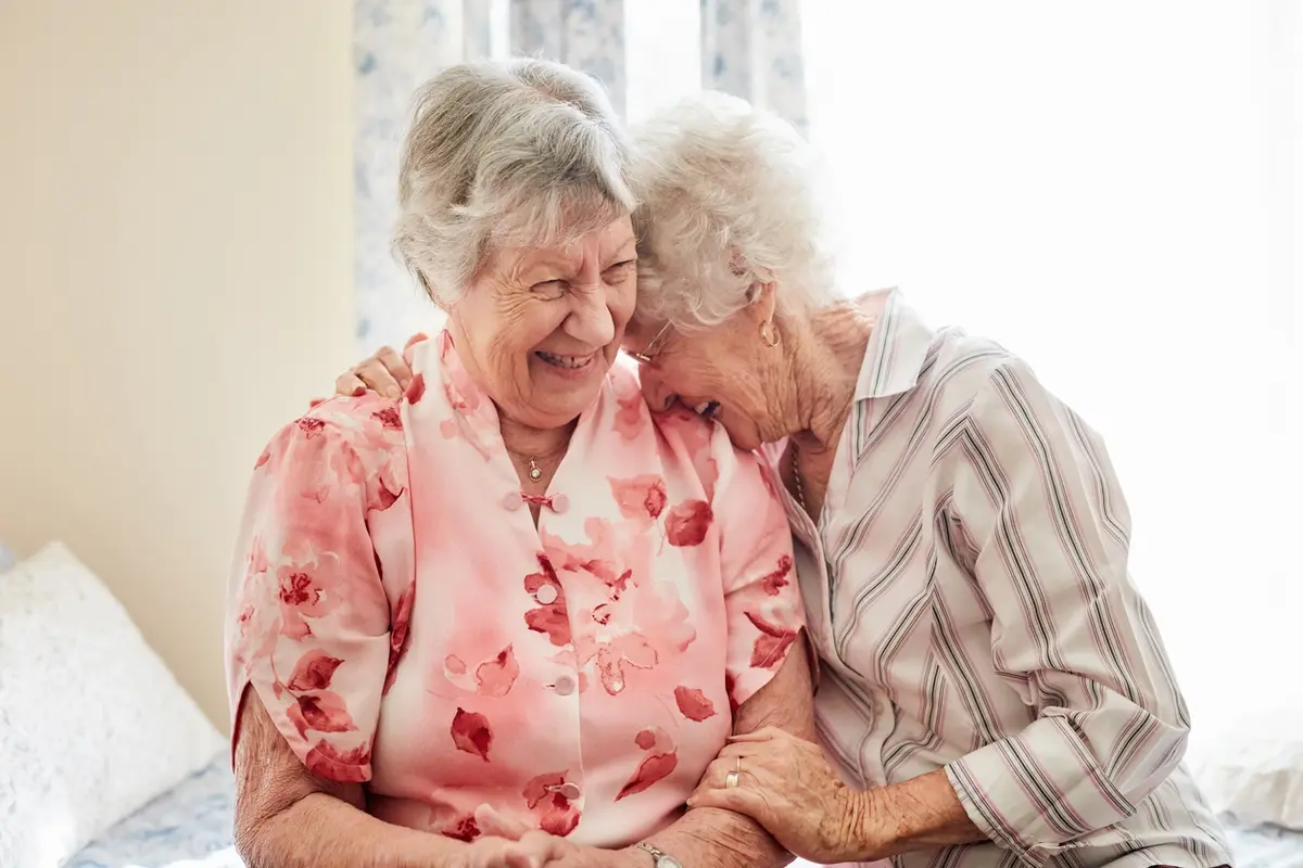 Shared Rooms in Memory Care Grandmother showing old photos with her adult grandson, reflecting shared rooms in memory care and the social connection that supports residents at Carefield Pleasanton