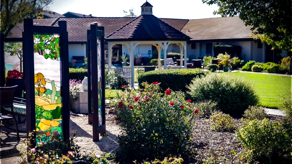 Assisted Living Garden Courtyard at Madonna Gardens Salinas Outdoor spaces in assisted and memory care: sunny garden courtyard with gazebo and stained glass art
