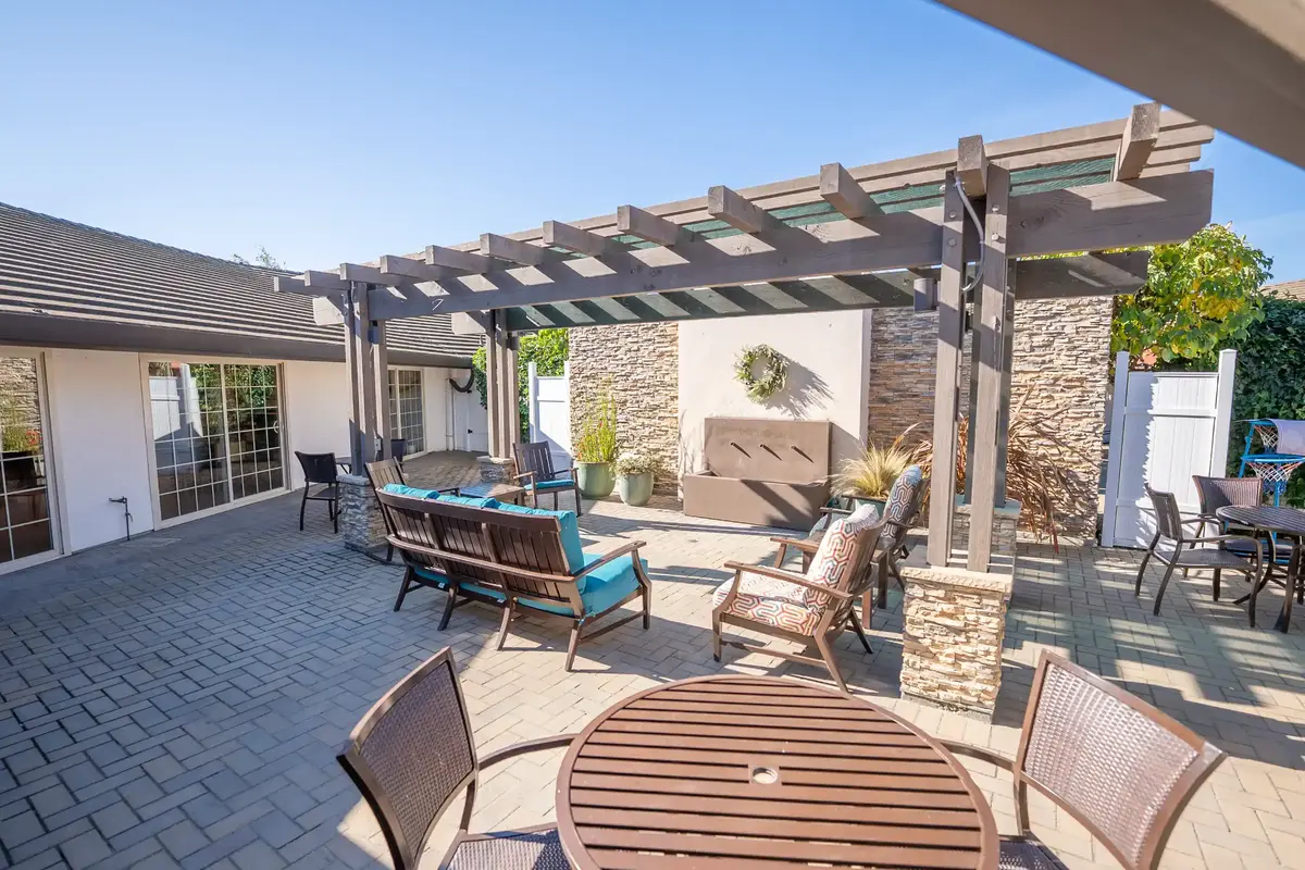 Assisted Living Patio at Madonna Gardens Salinas Spacious assisted living patio with shade umbrellas, fire pit, outdoor furniture, and citrus tree at Madonna Gardens, opened directly from the assisted living dining room.