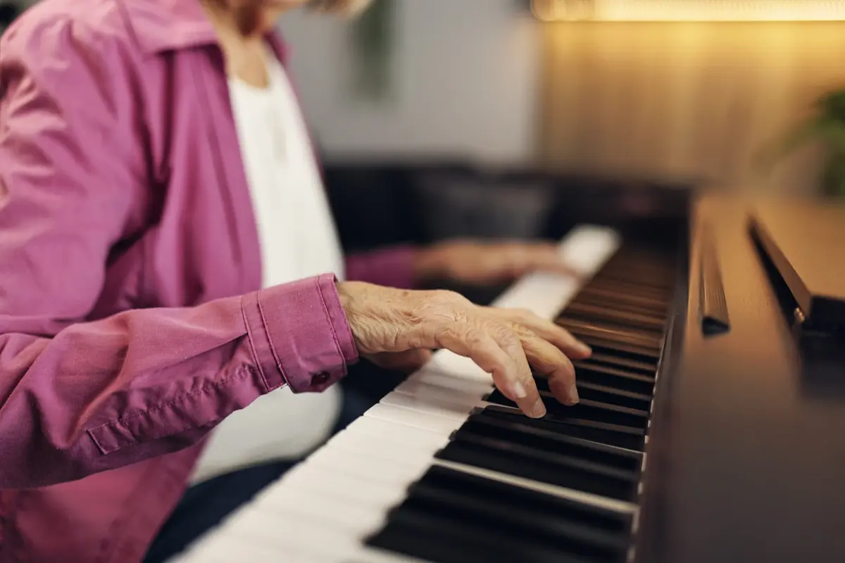 Senior woman playing piano during a music therapy for dementia activity