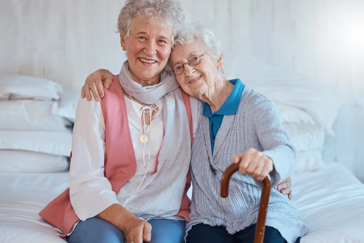 private-rooms-vs-shared-rooms-memory-care-companionship Senior friends smiling together, illustrating private rooms vs shared rooms in memory care.